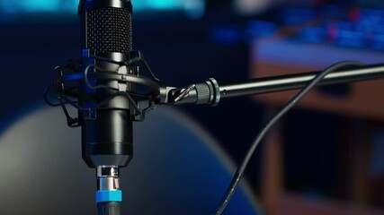 Close up shot of podcast microphone used to record internet show for online livestreaming channel. Streaming sound capturing and recording podcasting tool in empty living room with neon lights