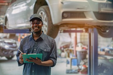 African maintenance male checking car, service via insurance system at automobile repair and check up center