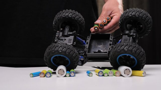 Technician installing batteries in remote control car