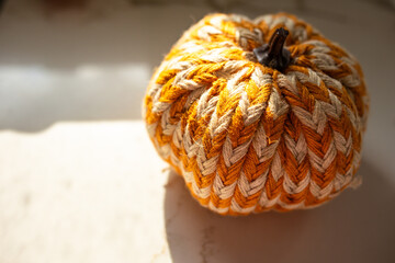 close-up of white and orange striped crafted pumpkin against a marble surface