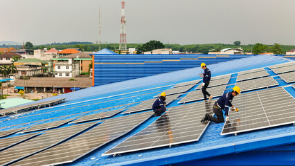 Naklejka premium Worker Technicians are working to construct solar panels system on roof. Installing solar photovoltaic panel system. Men technicians walking on roof structure to check photovoltaic solar modules.