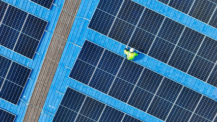 engineer man inspects construction of solar cell panel or photovoltaic cell by electronic device....