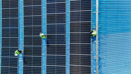 Worker Technicians are working to construct solar panels system on roof. Installing solar photovoltaic panel system. Men technicians walking on roof structure to check photovoltaic solar modules.