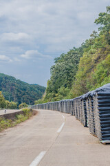 Plastic-covered bags of fertilizer stacked along a abandoned rural highway in rural South Korea