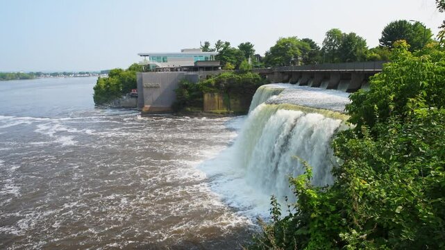 Rideau Falls on a warm summer morning flowing into the Ottawa River with Tavern on the falls in background