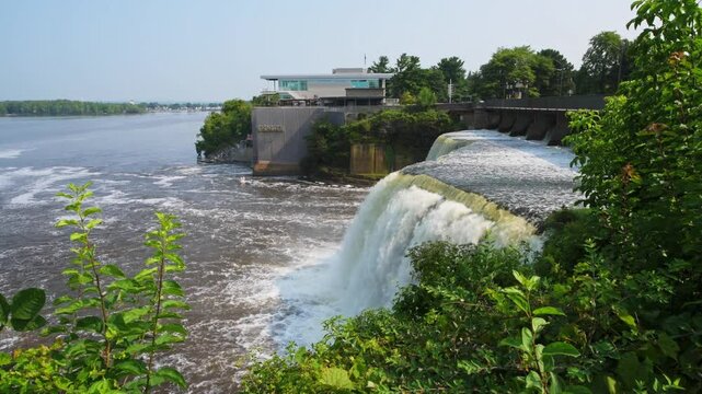 Rideau Falls on a warm summer morning flowing into the Ottawa River with Tavern on the falls in background