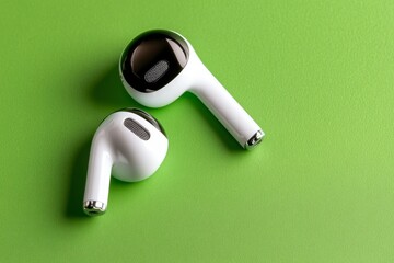 A single pair of wireless earbuds on a clean background, representing portable communication and simplicity
