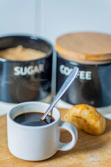 Hot Espresso coffee,in a small,white cup,with a teaspoon inside, just after stirring,Worcestershire,United Kingdom.
