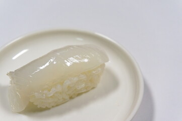 この画像は、いかのお寿司（squid sushi）が主役です。
