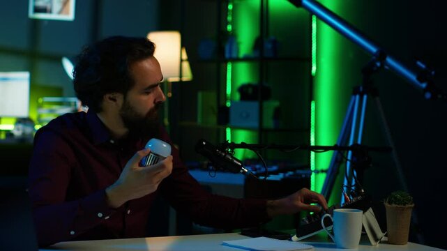Entertainer using light bulb to create atmospheric mood while entertaining audience. Disheveled man in apartment using light to create spooky vibe, pretending to be electrocuted, camera A