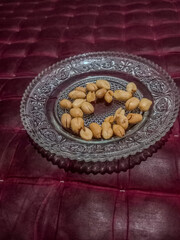 Fried peanuts served on a glass plate