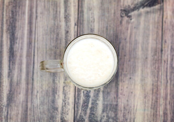 glass of warm cereal milk on a wooden board