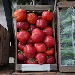 Crates of fresh fruits and vegetables in a traditional grocery store with a variety of healthy and colorful products displayed on wooden shelves