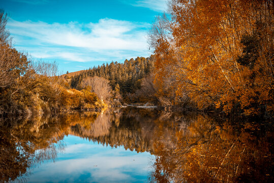 Tabaquillo river with autumn trees surrounding the calm water mirror at San Miguel de los Rios in Cordoba, Argentina