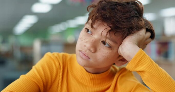 School, kid and tired with thinking in library for development problem, education and academic fatigue. Exhausted, student and boy with anxiety at academy for dysgraphia, burnout or handwriting issue