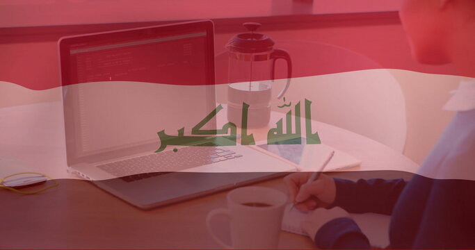 Iraqi flag image over person working on laptop and holding coffee cup - Powered by Adobe