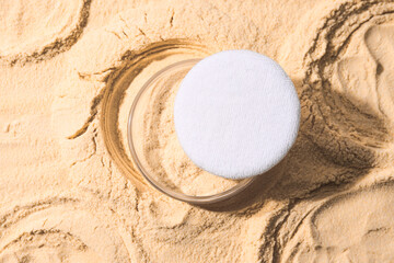 A bottle of light-colored powder on a yellow background.