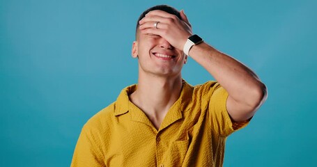 Stress, crisis and man in studio thinking of failure, anxiety or mistake with bad decision. Problem, regret and person with hand on face for shame, frustration or disappointment by blue background.