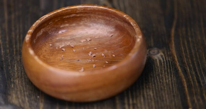 chocolate crumbs in a wooden bowl, round wooden bowl with chocolate pieces and chips