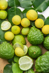 Pile of kaffir limes and limes or Citrus aurantifolia arranged, on leaves background