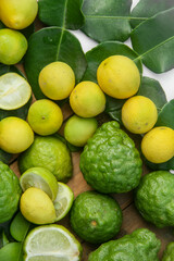 Pile of kaffir limes and limes or Citrus aurantifolia arranged, on leaves background