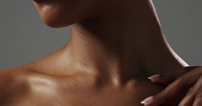 Touching, neck or woman with closeup, glow or smooth texture for shine on white background. Body treatment, hand or zoom of girl model in studio with wellness, cosmetics or beauty skincare results