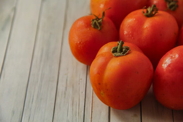 Sliced and whole tomatoes arranged on a wooden table