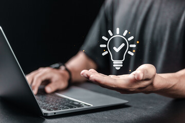Person using laptop with creative light bulb icon for business solution idea concept. planning strategy, analysis solution and development.
