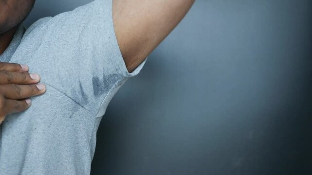 Young man sniffing his armpit, Bad smells concept.