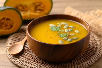 Pumpkin soup in wooden bowl, Homemade food in autumn season