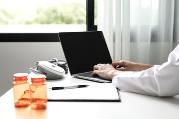 Female doctor holding a medicine bottle is checking the quality of medicine for any side effects the patient or not and recording patient information at the hospital. medical and health care concept