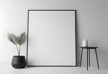 Minimalist interior with a blank picture frame, a black pot with a green plant, and a small black table with a white vase on a white wooden floor.