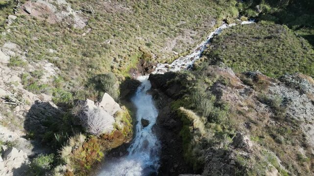 Aerial descends remote Caryacuyo waterfall in arid mtns of south Peru