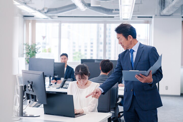 オフィスで上司から叱責をされる若い女性社員