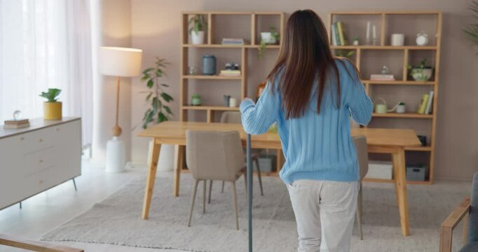 Happy woman, dancing or sweeping to clean living room with broom for floor, ground or hygiene in home. Girl, funny person or cleaner with spring cleaning music for working to stop dust, dirt or germs