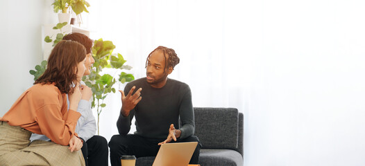 Multinational people talking while looking at a laptop in a lobby