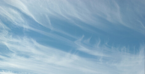 Fototapeta premium Banner with a blue sky and winter clouds being swept away by the wind, providing ample copy space.