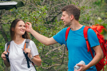 A happy couple shares a joyful moment outdoors while hiking, surrounded by beautiful, lush greenery and nature