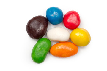 Round multi-colored glazed candies on a white background. Sweet candies close-up view from above.