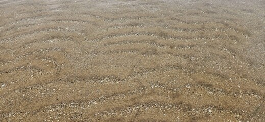 Ocean wave texture on sand beach in water background landscape.