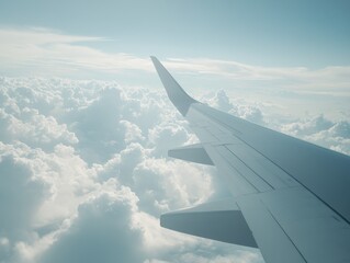 A stunning view from an aircraft wing above fluffy clouds under a serene sky, capturing the essence of travel and adventure.