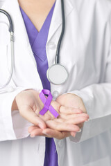 Doctor holding purple Ribbon for Violence, Pancreatic, Esophageal, Testicular cancer, Alzheimer, epilepsy, lupus, Sarcoidosis and Fibromyalgia. Awareness month and World cancer day concept