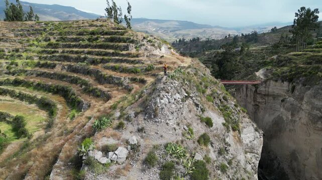 Aerial orbits man on agriculture terraces in Colca River canyon, Peru