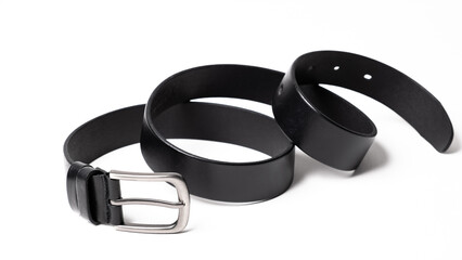 Black leather belt with matte metal buckle close-up isolated on white background. Fashionable unisex accessory for trousers, jeans, dress. Luxury male strap for man and woman. Haberdashery goods