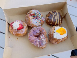 Assorted Gourmet Cronuts in Bakery Box on Table

