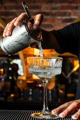 Bartender serving margarita cocktail in glass with spicy rim. Bar and experiences.