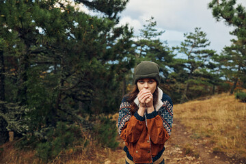 A young woman in distress standing on a dirt road in the tranquil woods, contemplating life's...