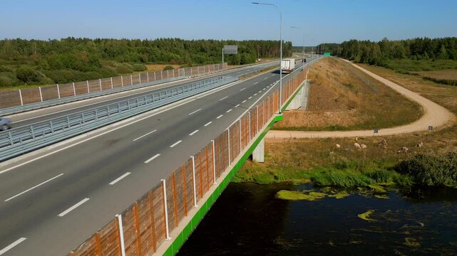 Trucks on expressway S8 road through forested land, Static shot