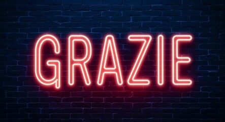 grazie word lettering glowing with neon light on dark brick wall background