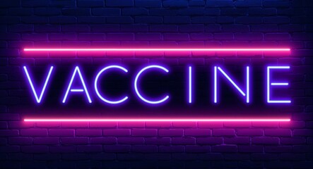 Obraz premium vaccine word lettering glowing with neon light on dark brick wall background